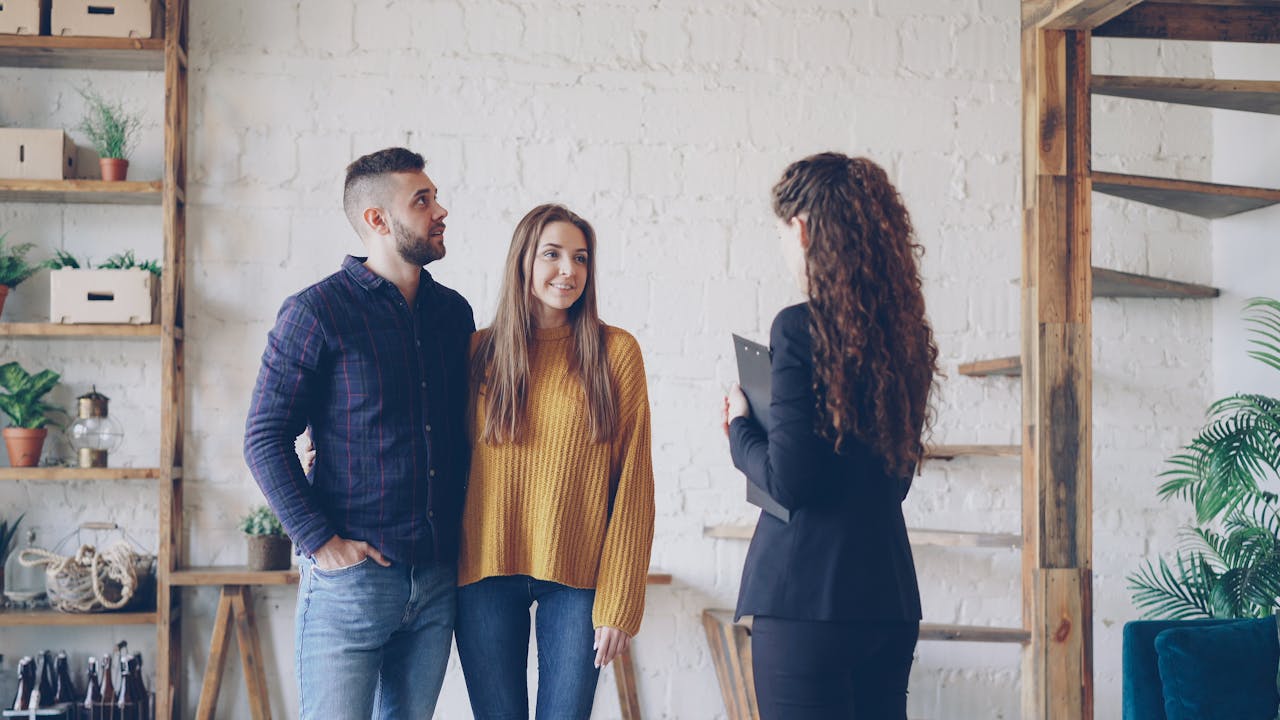 Young couple consulting a real estate agent in modern interior setting.