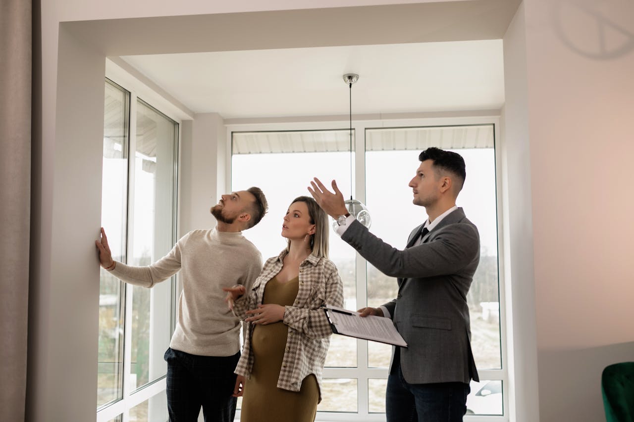 Mastering the First Impression: Your intriguing post title goes here A young couple inspects a modern apartment with a real estate agent during a daytime viewing.