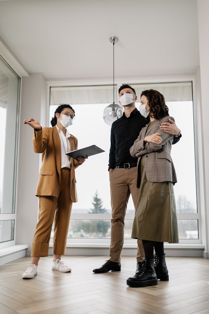 A couple in face masks tours a property with a real estate agent during the new normal.